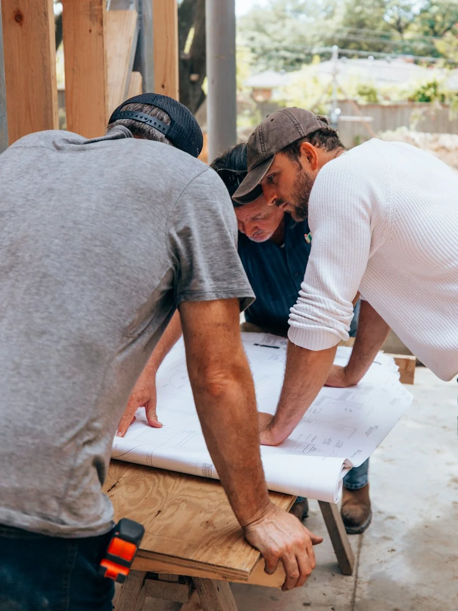 Contractors reviewing blueprints on a job site