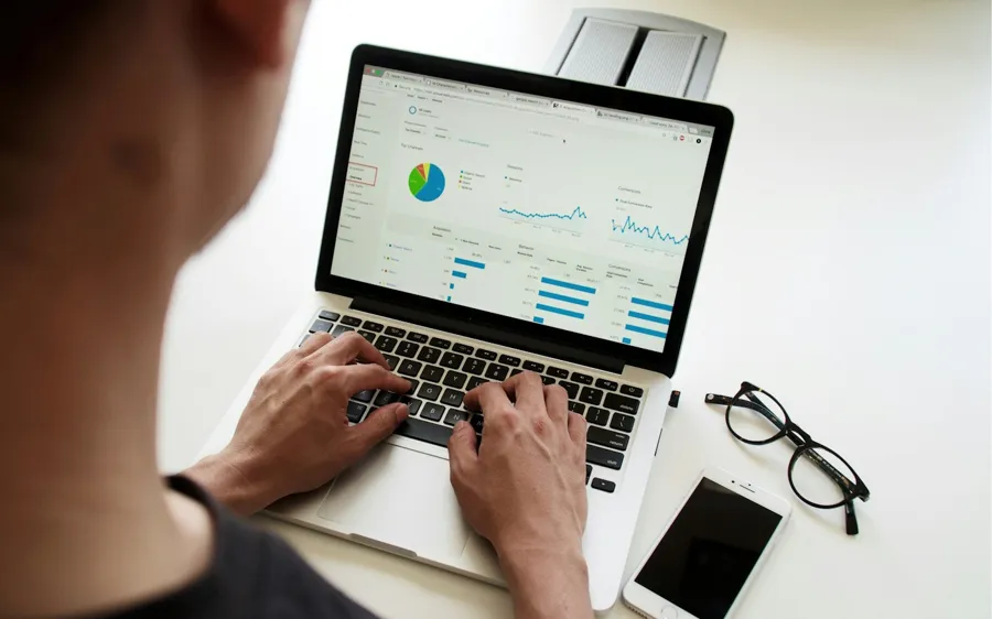 Marketer reviewing ad performance charts on a laptop